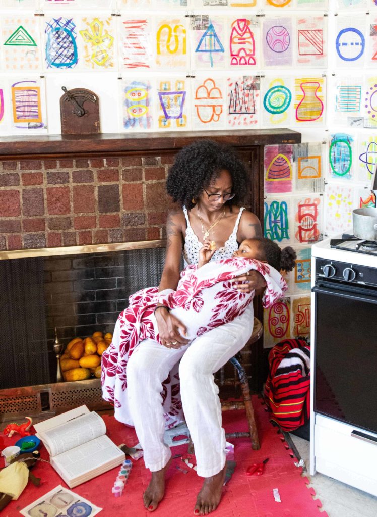 Tashi Colston holds her daughter in the Soul Kitchen in Rites of Passage.