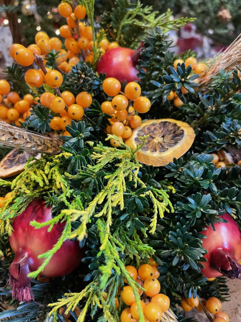 A centerpiece made of evergreens, winterberry and oranges sits bright in the winter market at Windy Hill in Stockbridge.