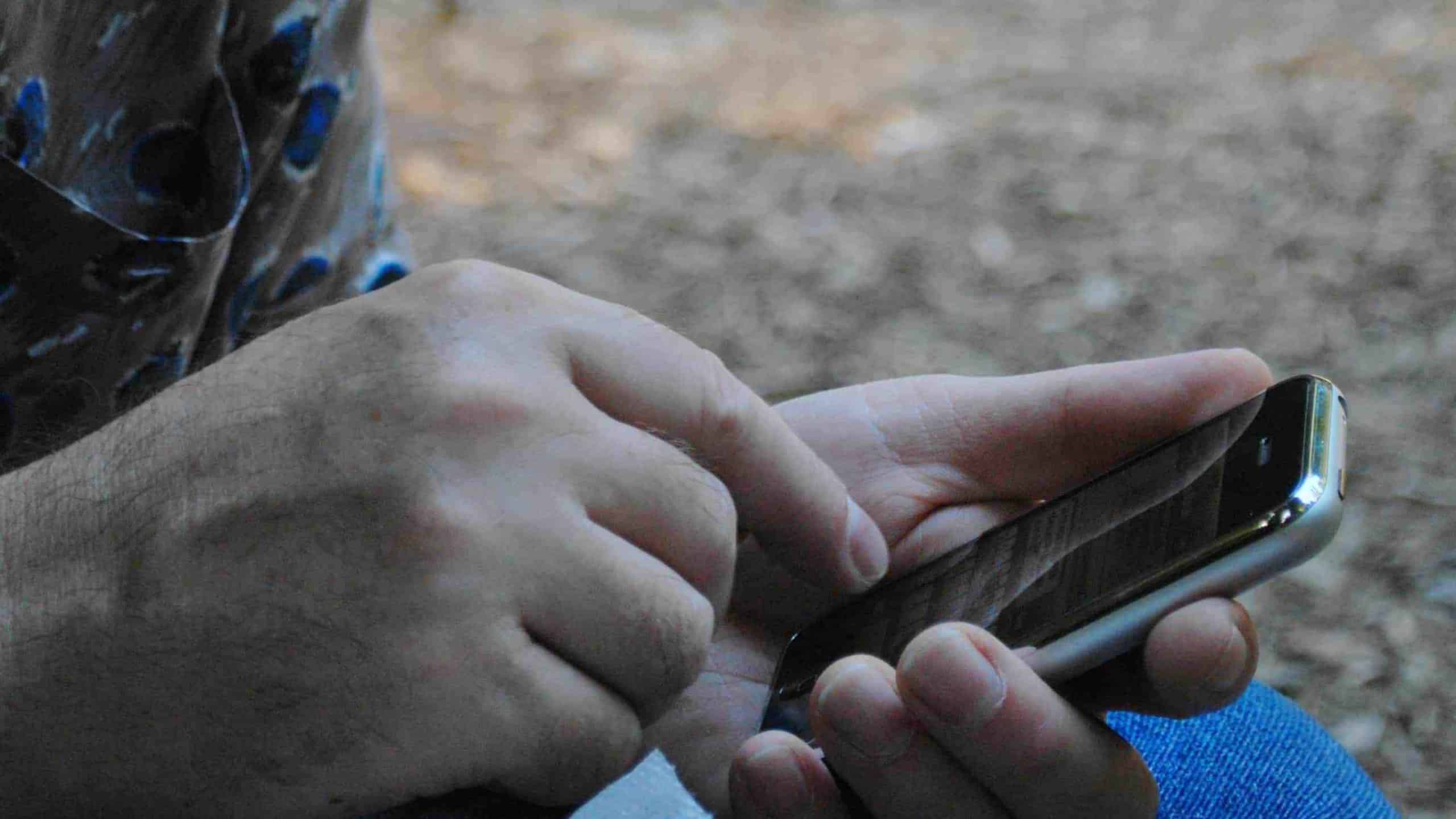 Hands tap the screen of an iphone. Creative Commons photo courtesy of Lisa Padilla