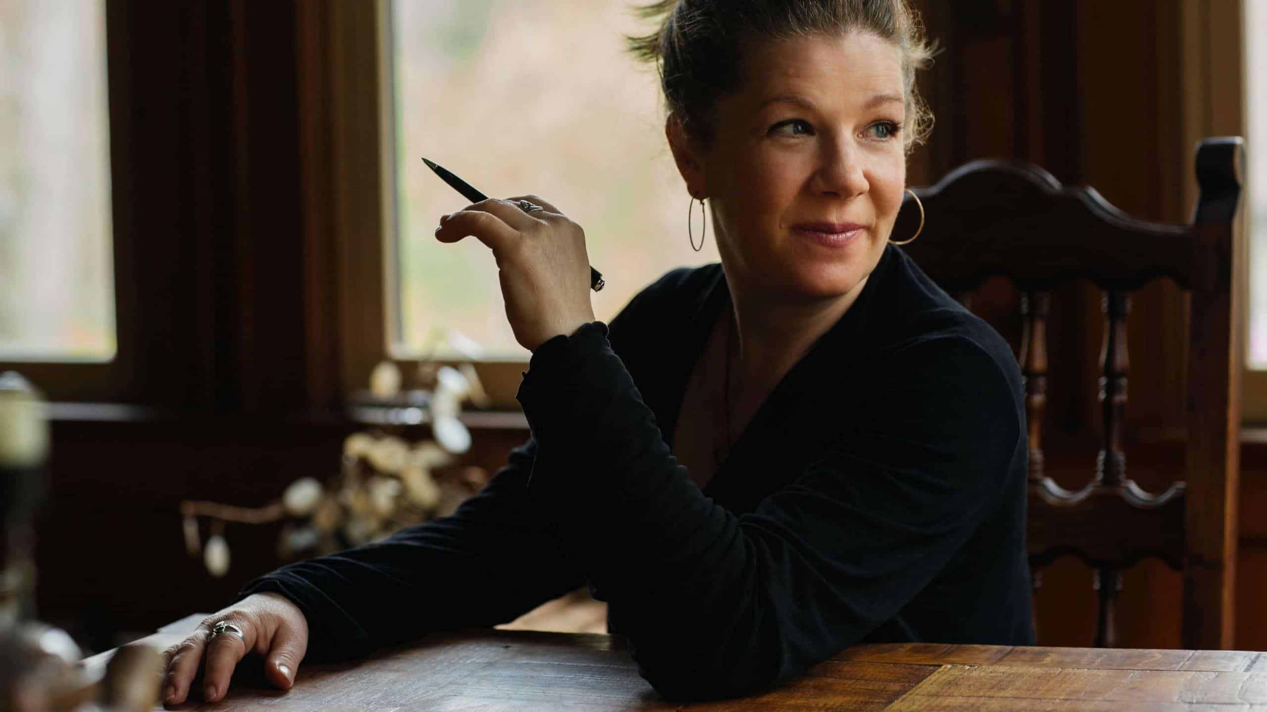 Nationally acclaimed singer-songwriter Dar Williams sits at her dining table with a pencil in hand. Press photo courtesy of the artist.