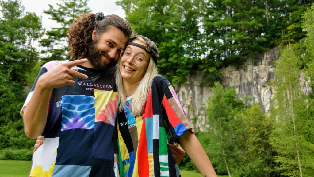 Sarah DeFusco and Andrew (Kirby) Casteel wear the bright upcycled patchwork clothing they make through their North Adams clothing brand, Wallasauce. Press image courtesy of the artists.