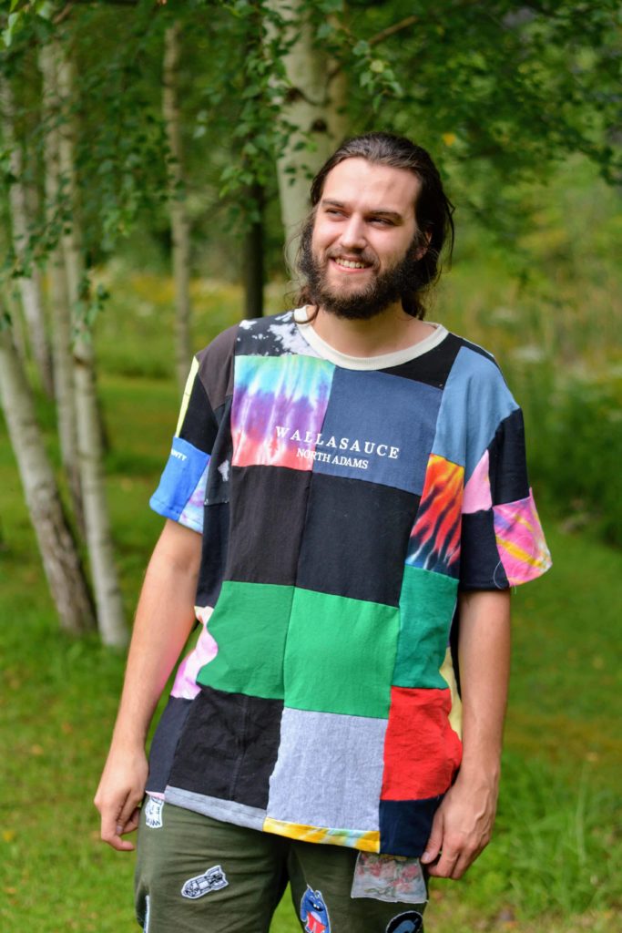 Andrew (Kirby) Casteel wears a bright upcycled patchwork shirt in the style of clothing he and Sarah DeFusco make through their North Adams clothing brand, Wallasauce. Press image courtesy of the artists.