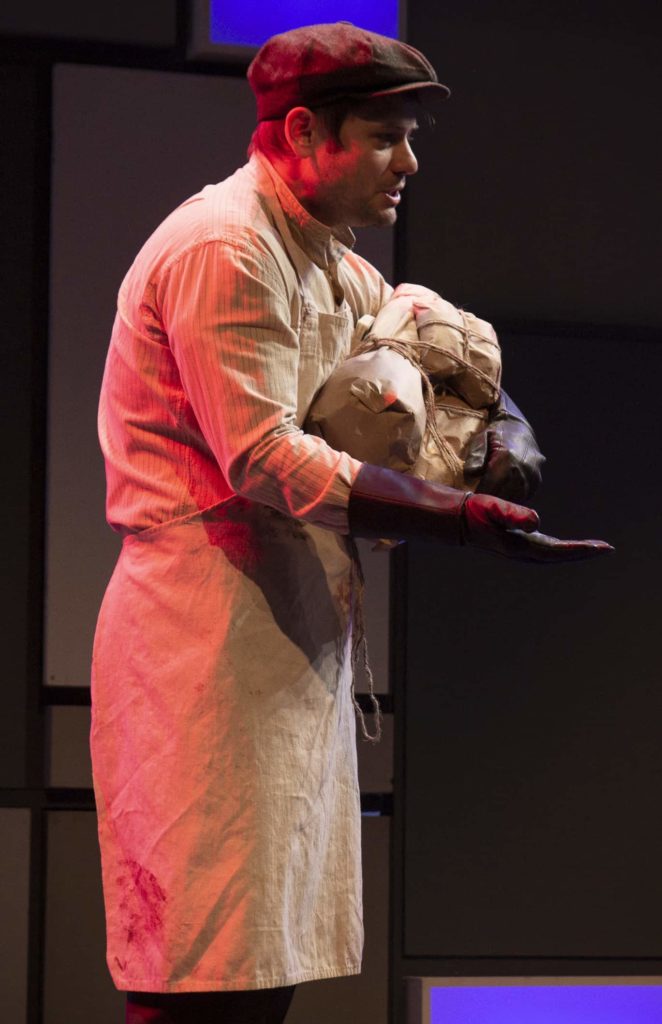 Doug Harris carries an amful of paper parcels, wearing a shopkeeper's apron, in 2021 in Barrington Stage's annual 10x10 festival of 10 new short plays. Press photo courtesy of BSC