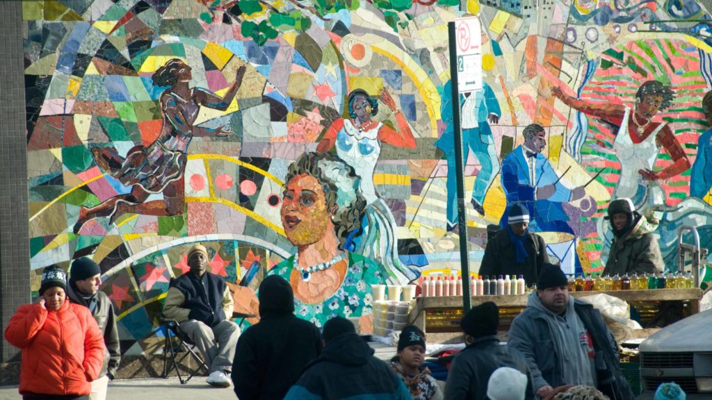 (A mural shows people dancing, a community swirled in color in Harlem, N.Y. Creative Commons courtesy photo