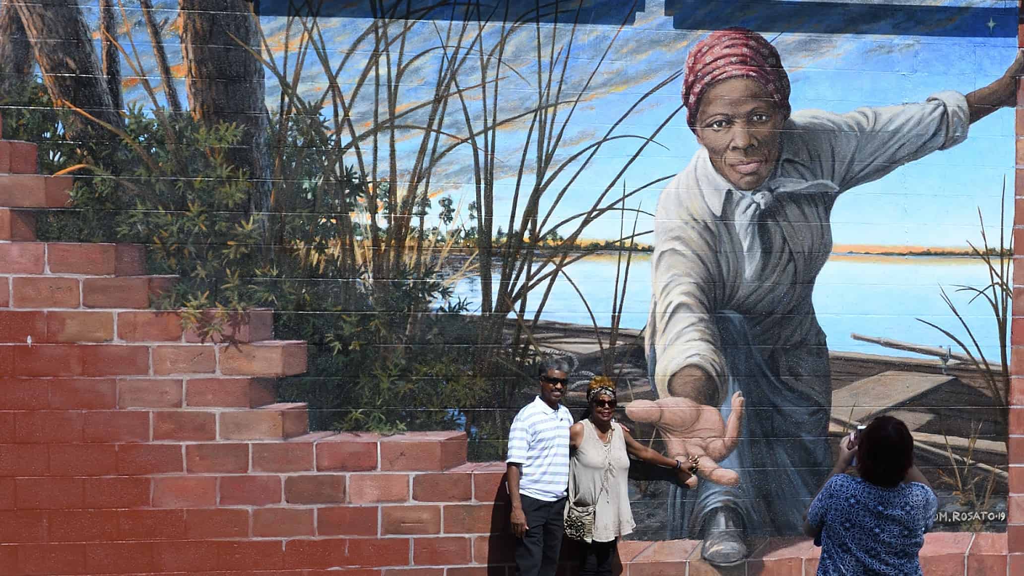 Harriet Tubman holds out a hand to Lt. Governor Rutherford, looking at the mural by Anthony DePanise in Mryland.