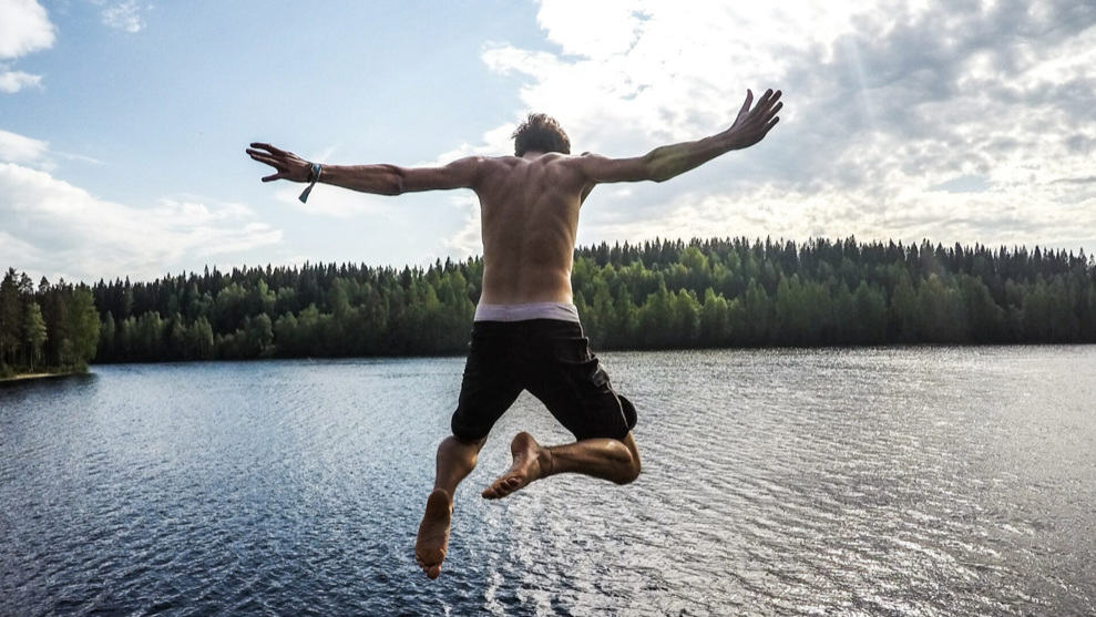 A boy jumps into a mountain lake, arms spread wide against the sky, in a summer image from the Berkshire International Film Festival. Press photo courtesy of the Mahaiwe