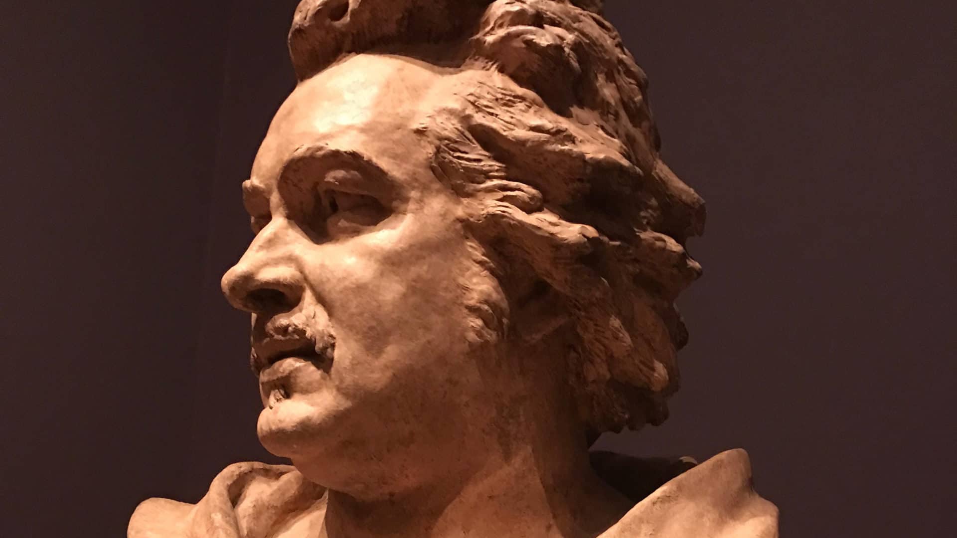 Light falls slantwise on the terracotta-colored bust of Pierre Hébert's 1877 sculpture of the French novelist Honoré de Balzac.