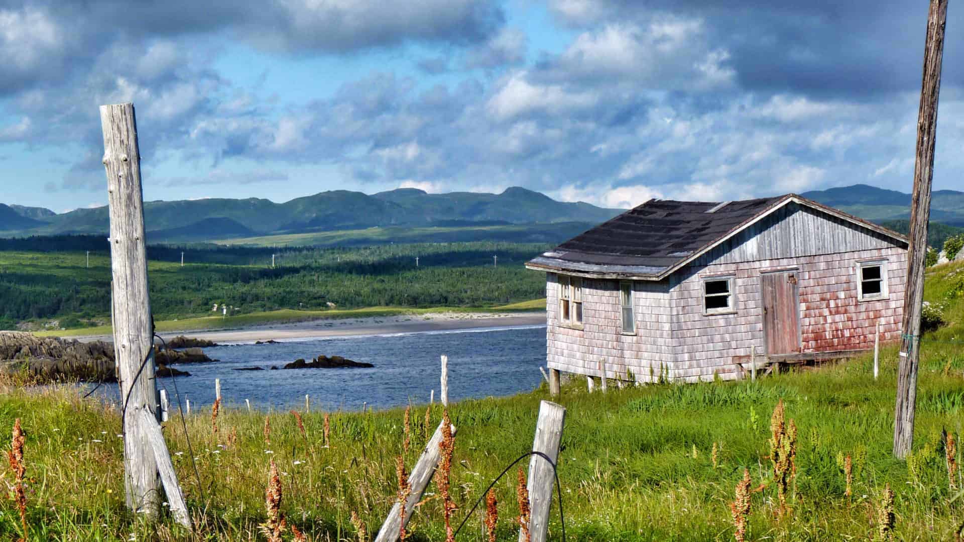A cedar shake house overlooks the water in Newfoundland.