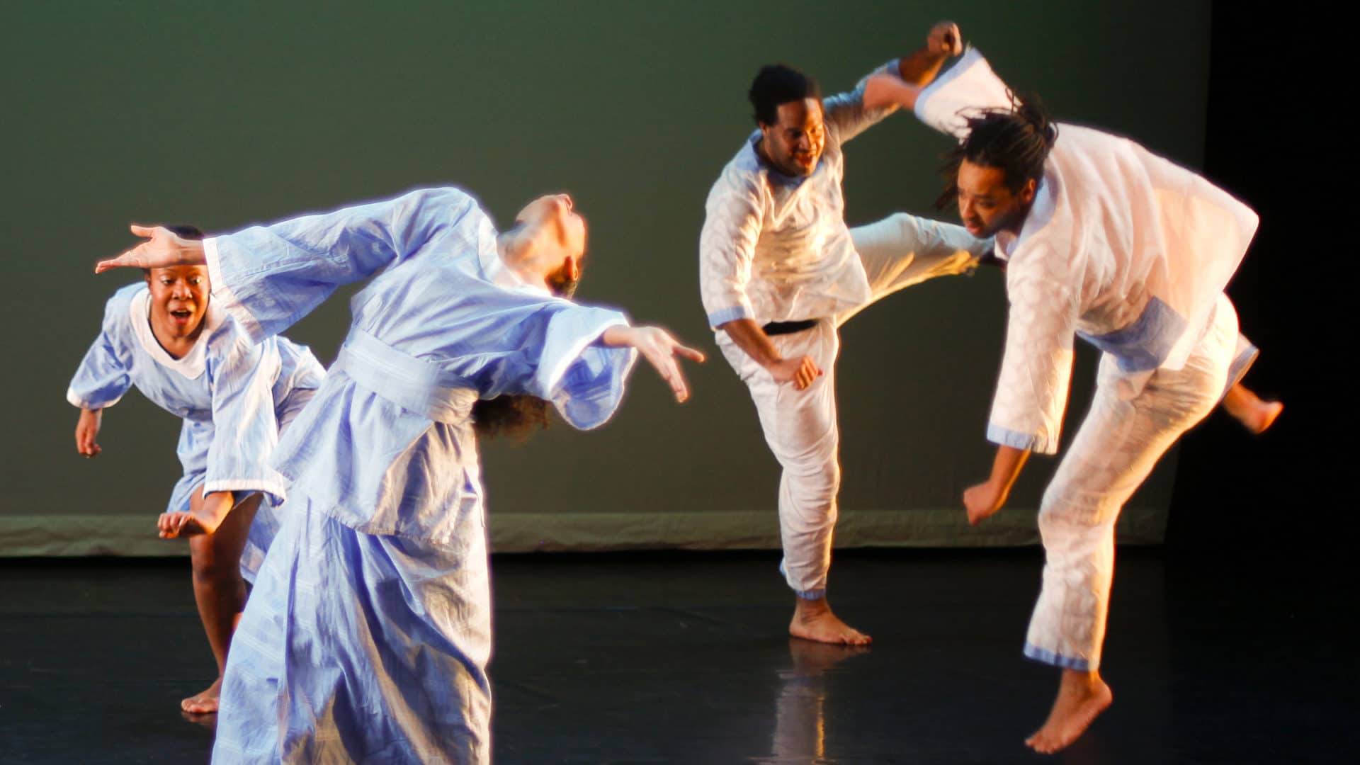 The Jamal Jackson Dance Company performs, weaving together in a deep green light. Press photo courtesy of Jacob's Pillow