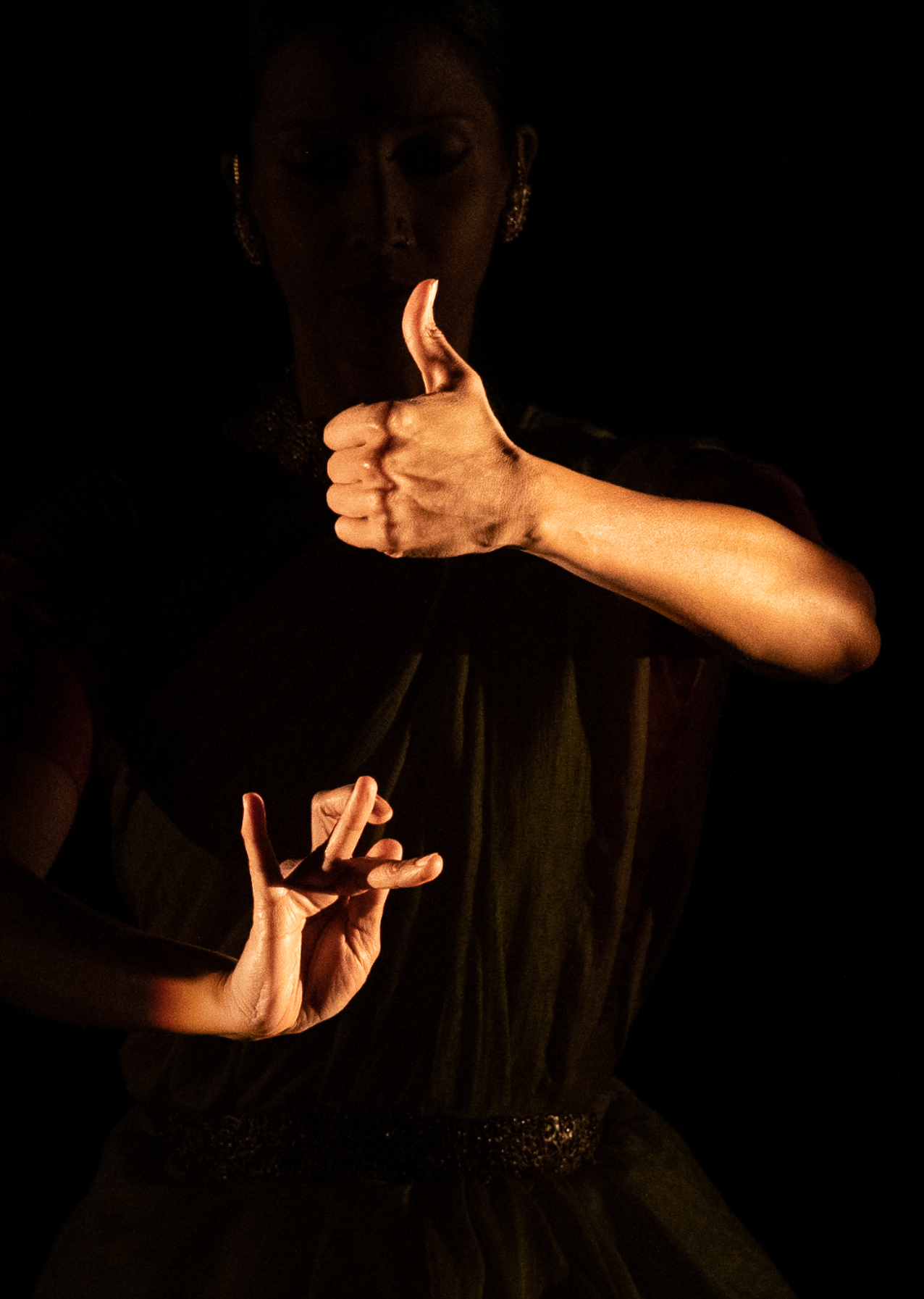 Internationally cclaimed bharatanatyam dancer Mythili Prakash's hands glow as she dances in shadow in America(na) to Me at Jacob's Pillow Dance Festival. Press photo courtesy of the Pillow