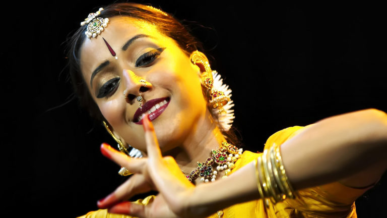 Internationally acclaimed Bharatanatyam dancer and choreographer Mythili Prakash, from Los Angeles, performs with expressive hands in a golden glow. Press photo courtesy of Jacobs Pillow Dance Festival