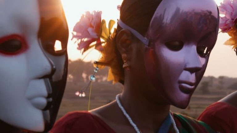 Masked performers stand illuminated in sunset light in O Horizon, an experimental documentary that explores the environmental teachings of prolific Bengali writer and poet Rabindranath Tagore.