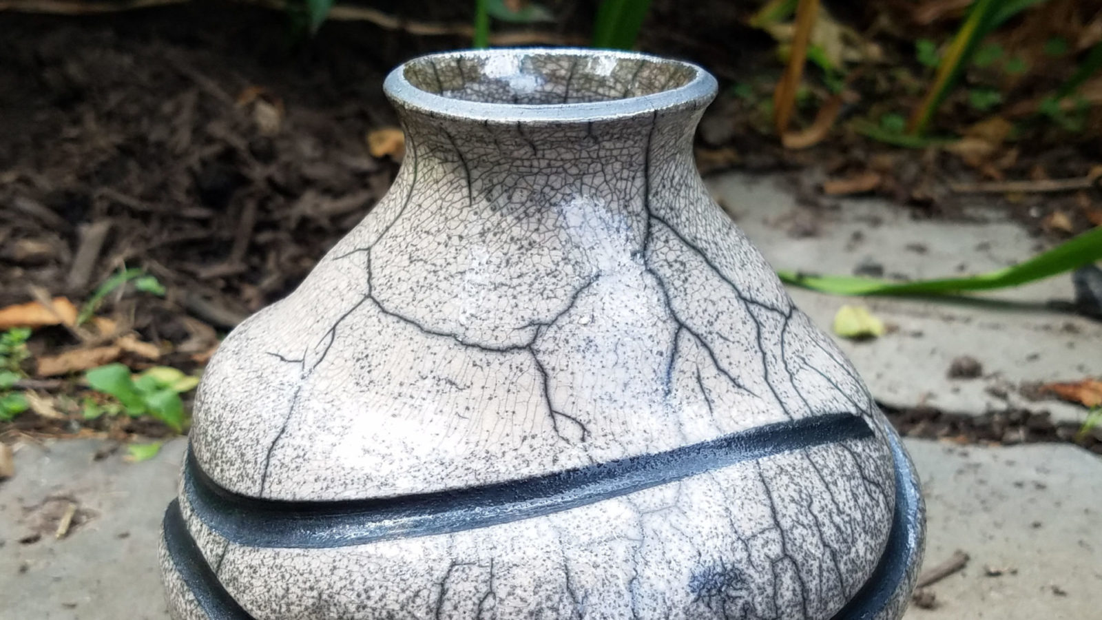 A raku vessel made by Donna Bernstein, a ceramics artist at the Clay Cottage gallery and studio, sits on a patio in the sun. Press photo courtesy of the artist