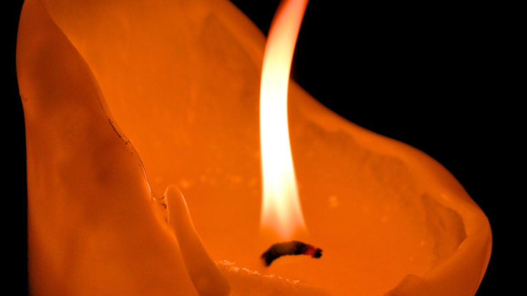 A candle burns in the dark. Creative Commons courtesy photo
