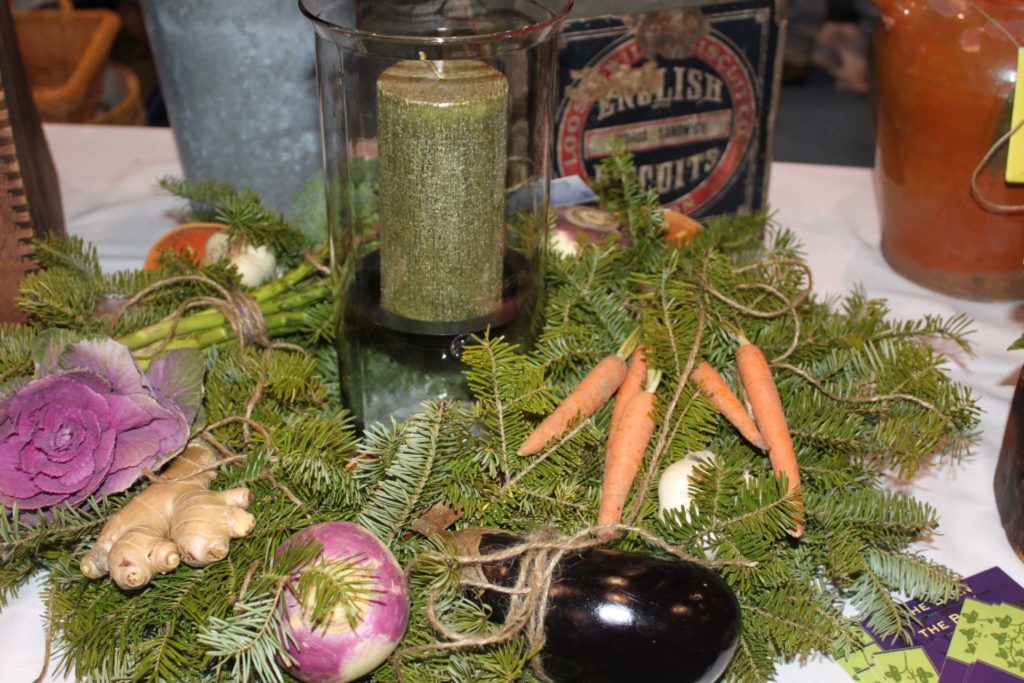 Evergreens for a centerpiece with carrots, deep purple eggplant and more at a Berkshire Grown farmers market.