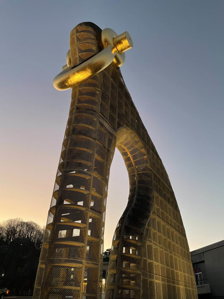The outdoor sculpture Big Bling catches sunset light in golden curves in North Adams.