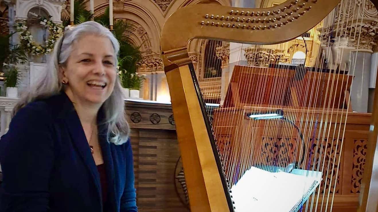 Harpist Christa Patton sits laughing with her Cellini, an Italian 17th-century-style harp made by Rainer Thurau.