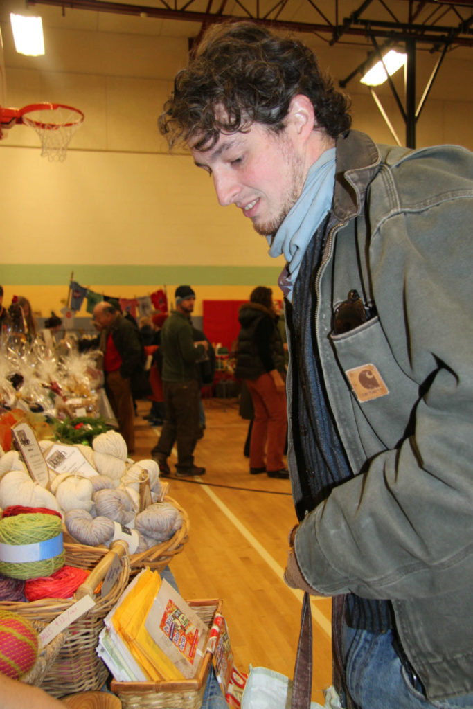Locals browse braids of garlic and locally grown and made goods at a Berkshire Grown indoor winter farmers market.