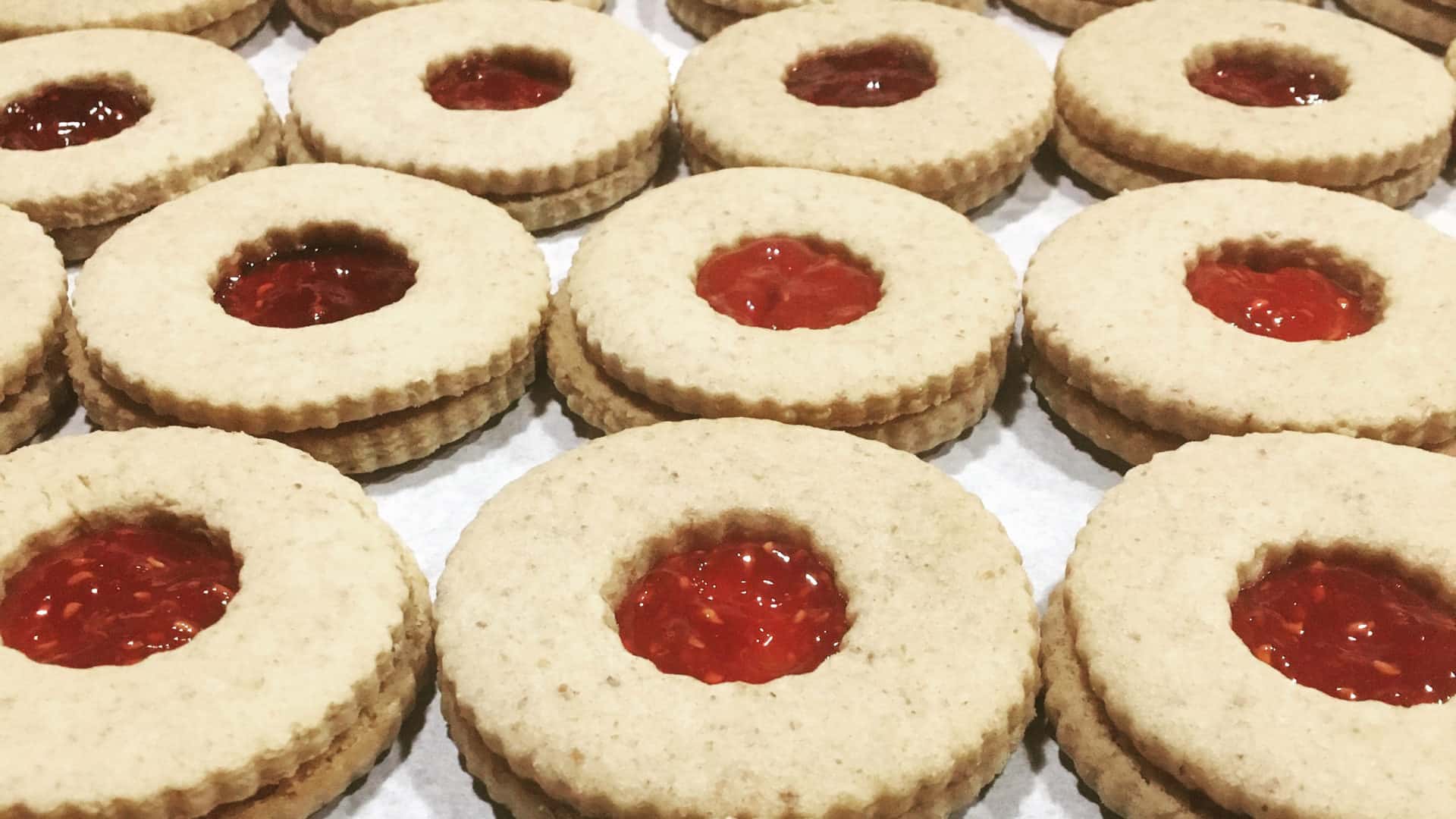 Jam sandwich cookies from Sweet Sam Bakes wait in bright rows. Press photo courtesy of the artist