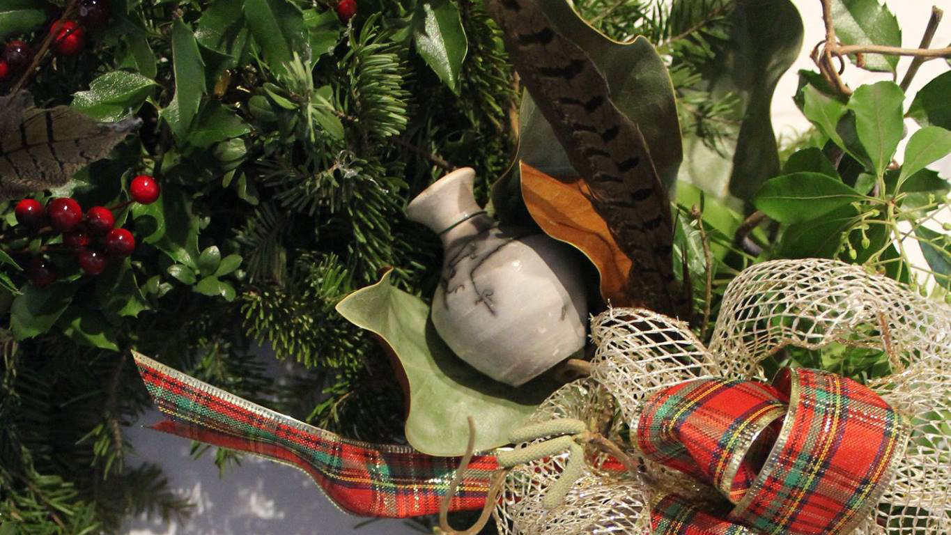 A wreath holds ceramic vessels among the evergreens at the annual holiday auction at the Litchtenstein Center for the Arts. Photo courtesy of Downtown Pittsfield