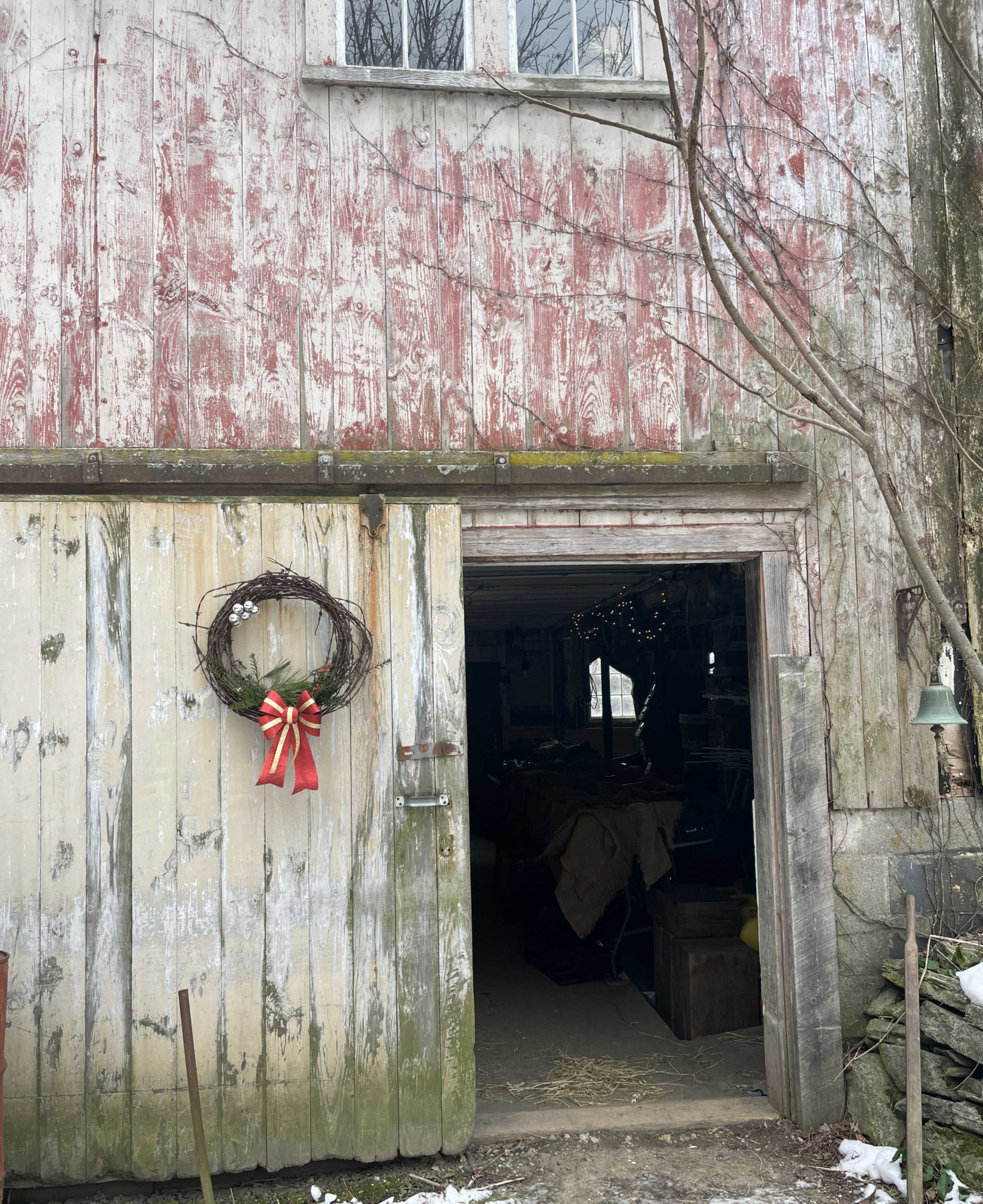 A wreath hangs by the door of the weathered barn at Moon in the Pond Farm in Sheffield.