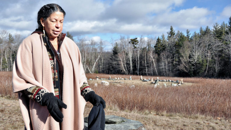 Satyana Ananda stands in the winter fields beside a stone cairn at Starseed, her sanctuary in Savoy.