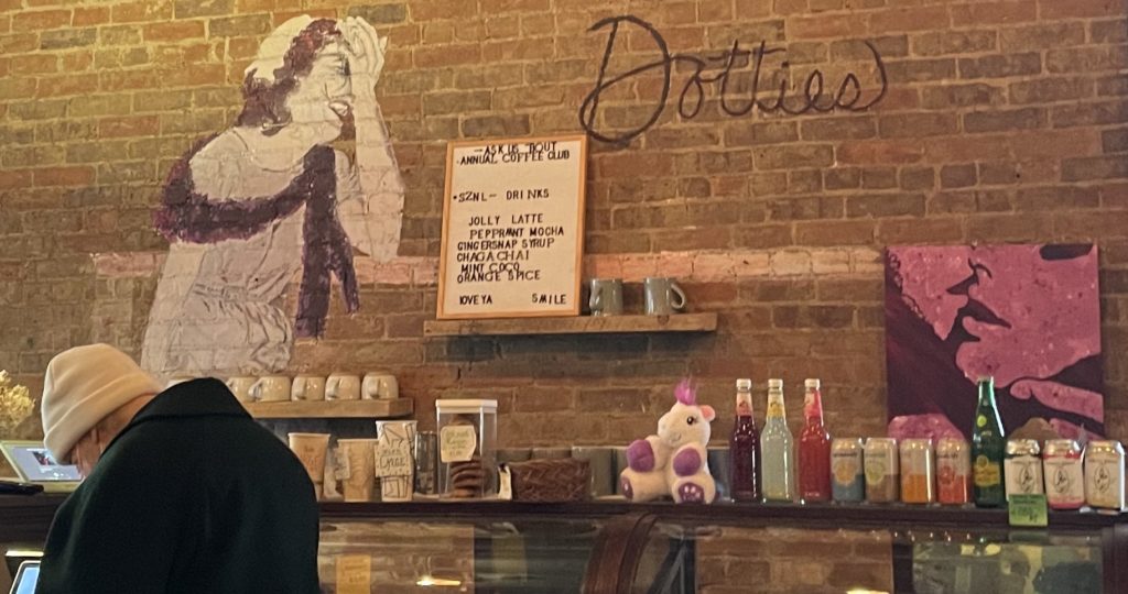 A woman laughs in a drawing on the brick wall at Dottie's Coffee Lounge.