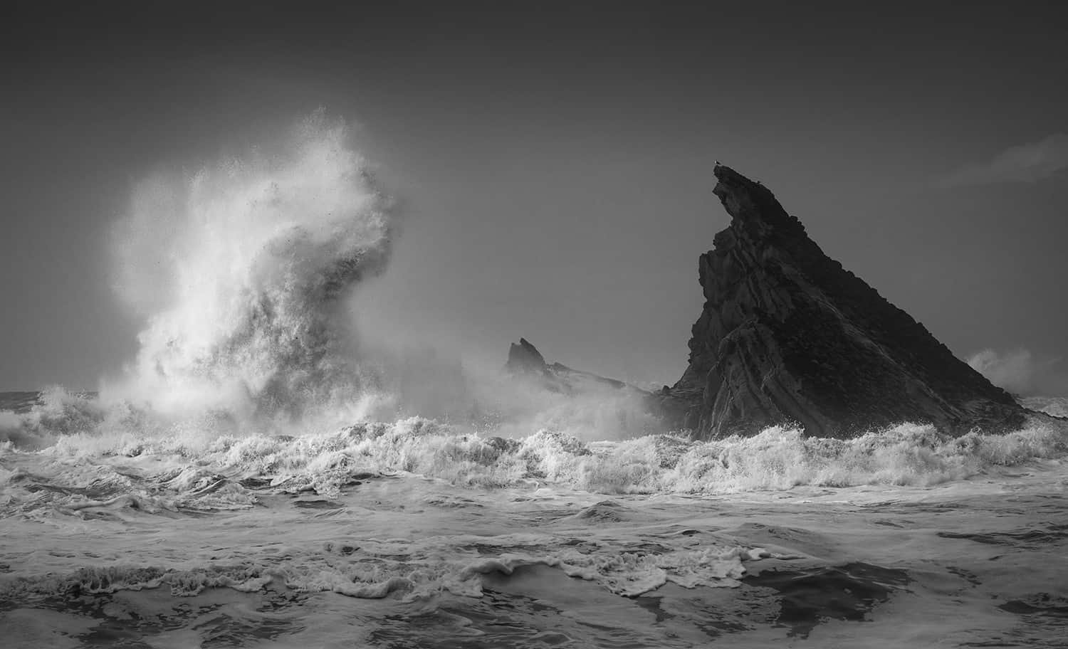 Rachael Talibart's 'Face-off' catches a wave towering against black rock on the coast of Oregon. Press photo courtesy of the Sohn Gallery