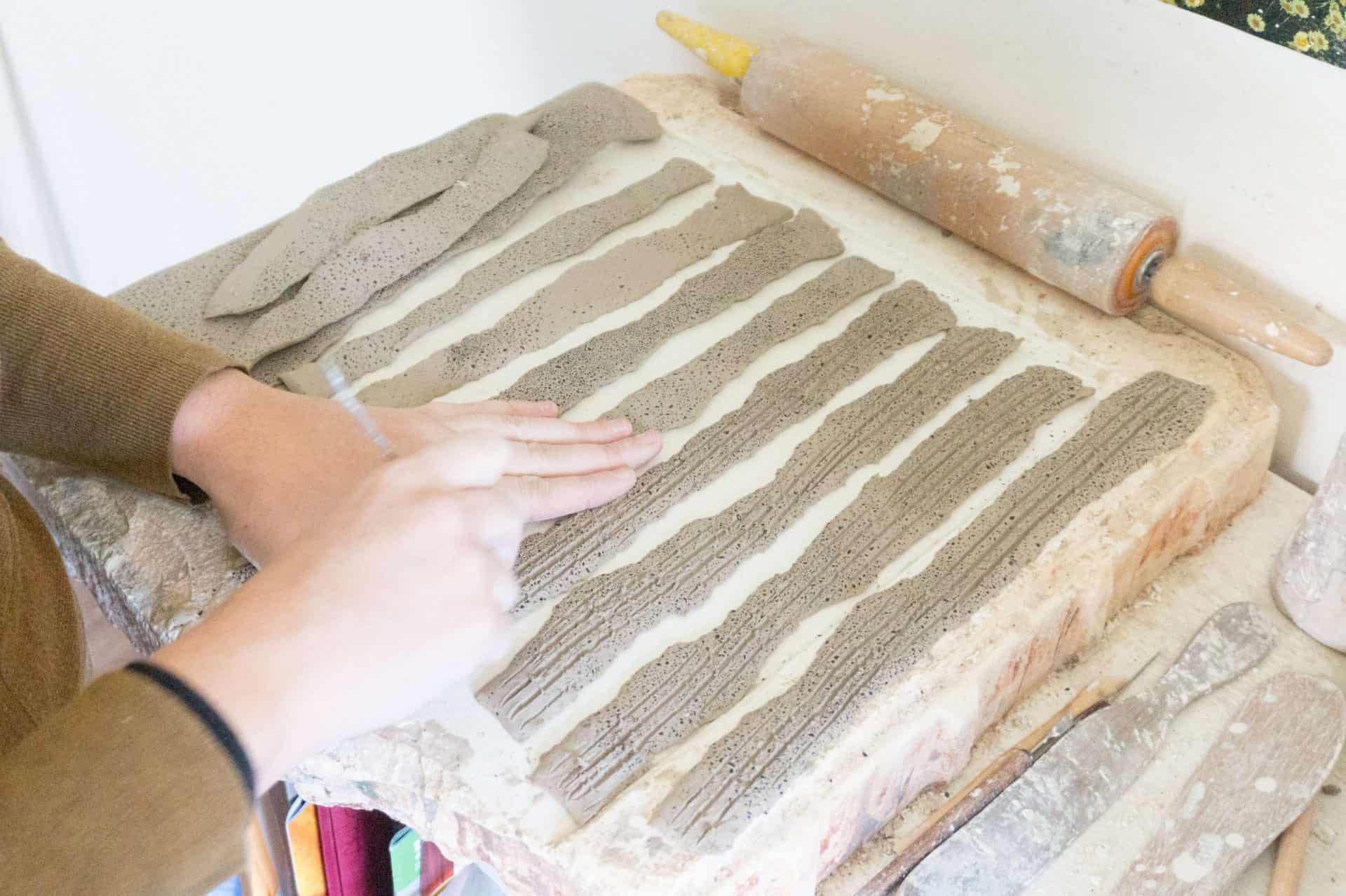 Ceramics artist Karlene Jean Kantner rolls and carves a slab of clay. Press photo courtesy of the artist