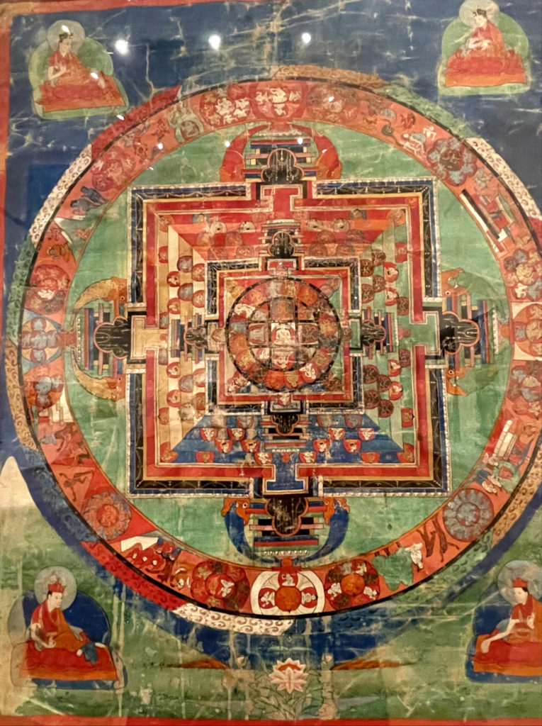 An 18th-century Mandala of the Luminous One, Nampar Nangdzé, shows a Buddha surrounded by fingures and nested geometric forrms in vivid color. Press photo courtesy of WCMA, taken by Kate Abbott