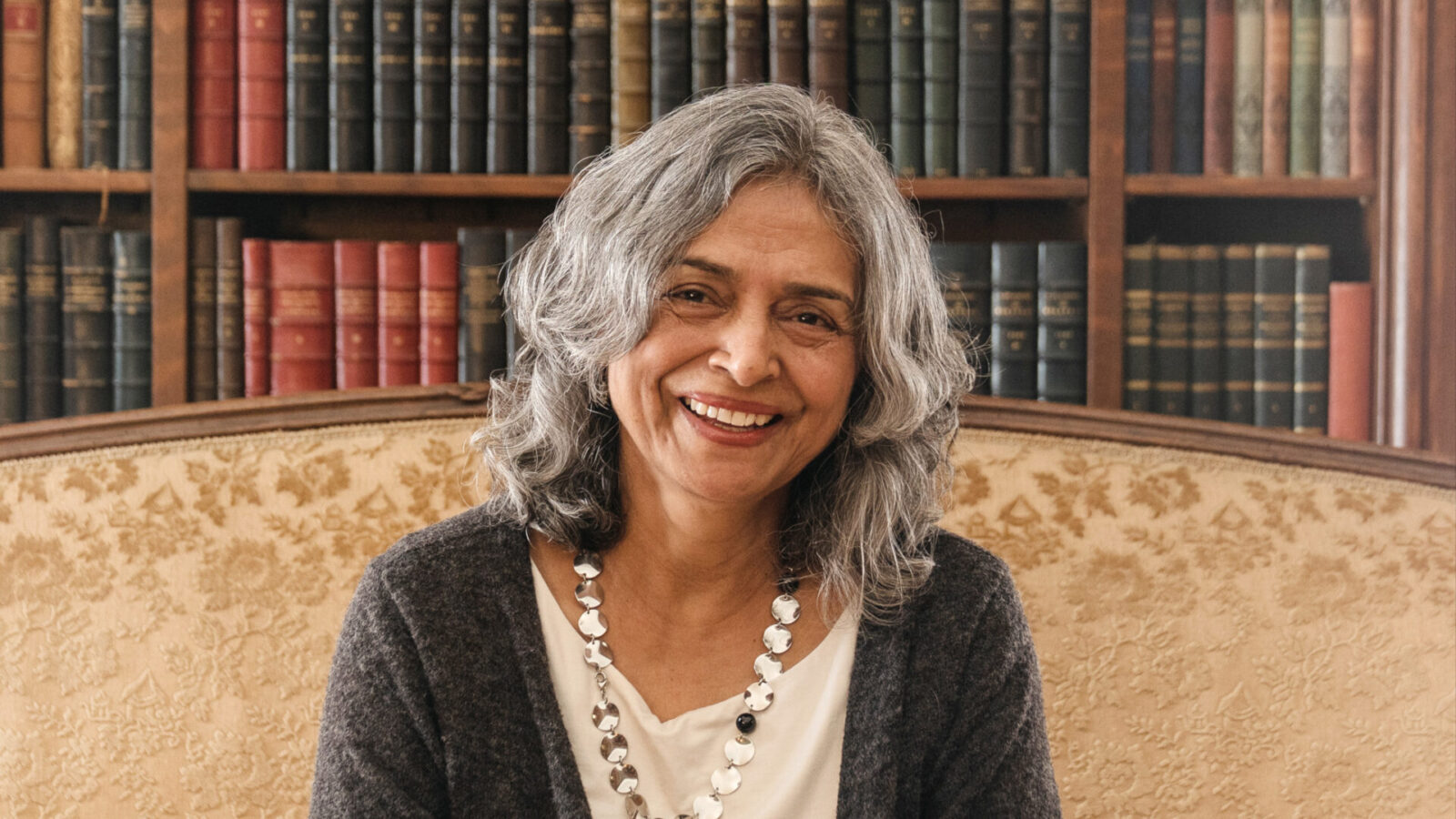 Parvati Ramchandani smiles, sitting in Edith Wharton's library, in the week when she and Cat Wei and Mario Giannone come to the Mount as writers in residence.