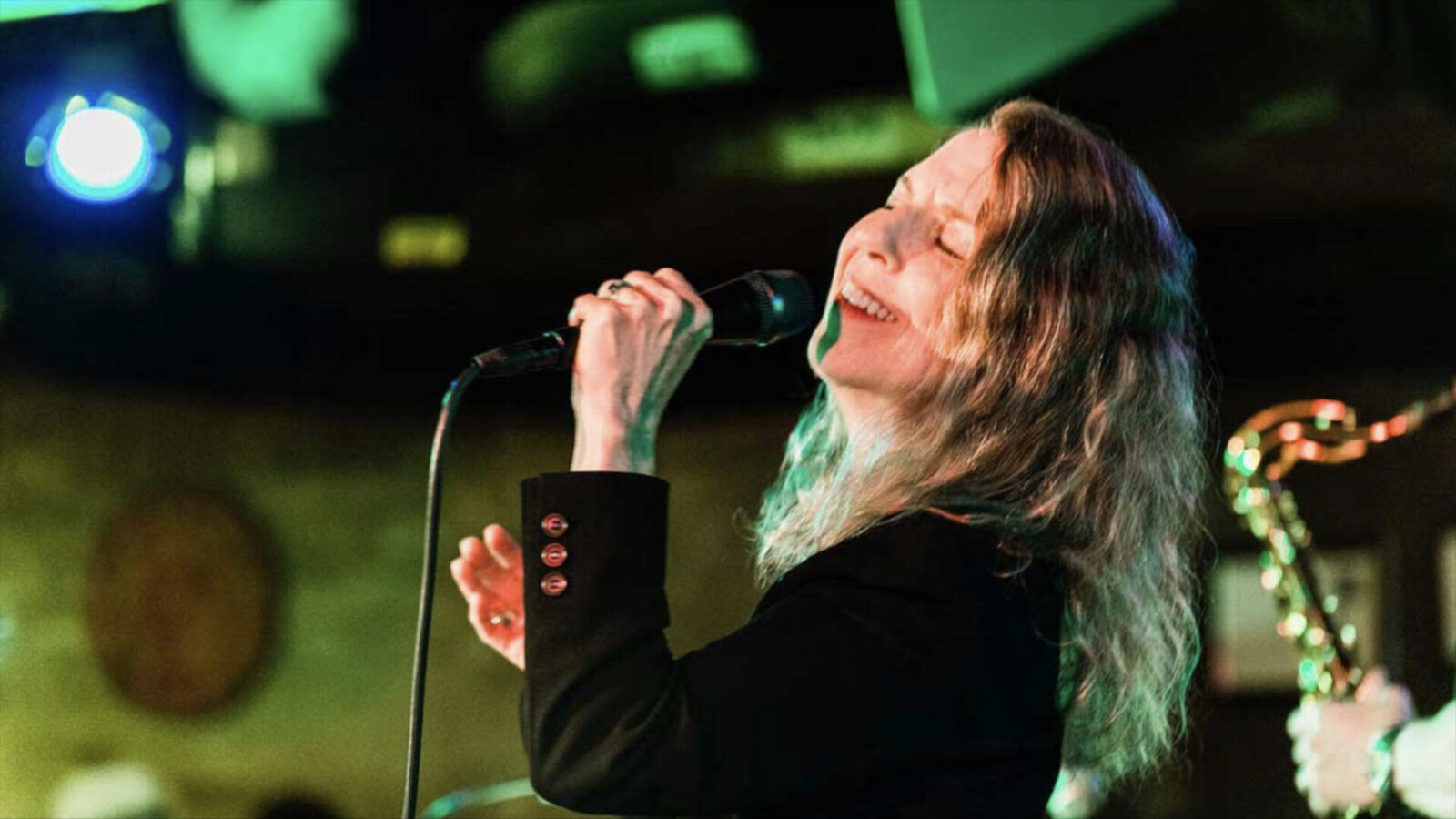 Jazz vocalist Suzi Stern performs in an outdoor concert at night. Press photo courtesy of the artist