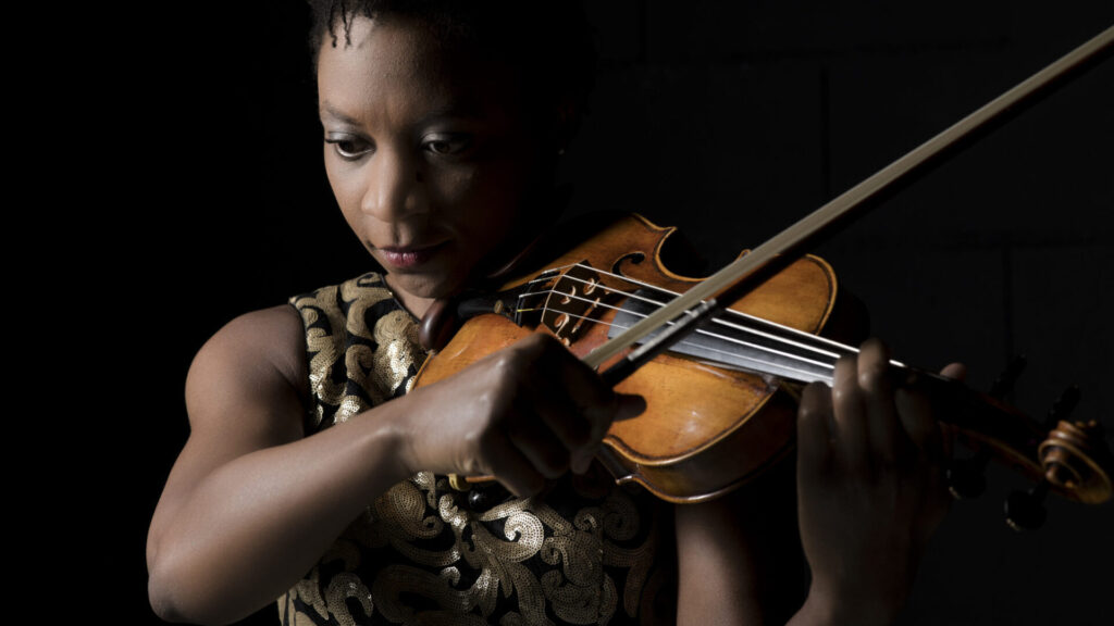 Acclaimed violinist Tai Murray, Instrumental Faculty with Tanglewood Music Center, bows her instrument.