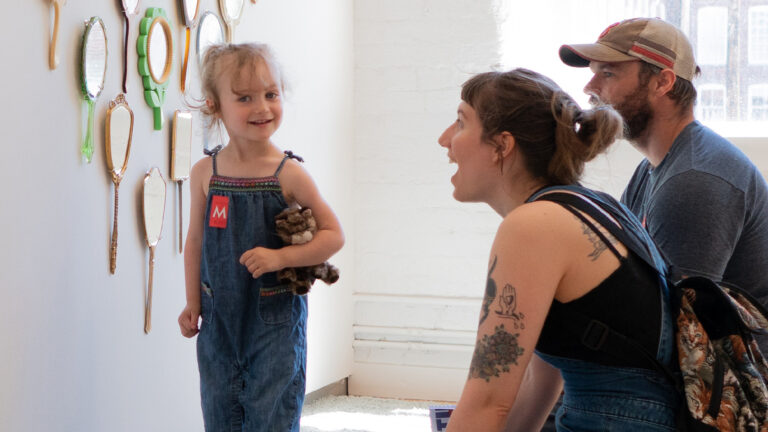 Parents and their young daughter laugh and exclaim over the art in Kidspace at Mass MoCA.