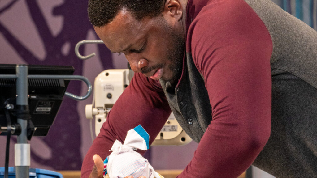 Andy Lucien lifts his newborn child in tiny father, a world premiere play by Mike Lew, at Barrington Stage Company. Press photo courtesy of BSC.