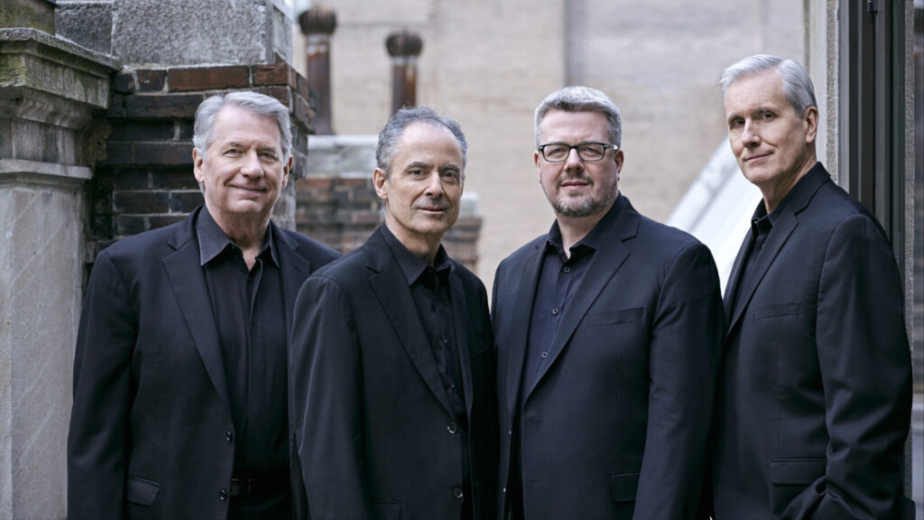 The Emerson String Quartet — Eugene Drucker on violin, Philip Setzer on violin, Larry Dutton on viola and Paul Watkins on cello — will stand in dark jackets on a city rooftop.