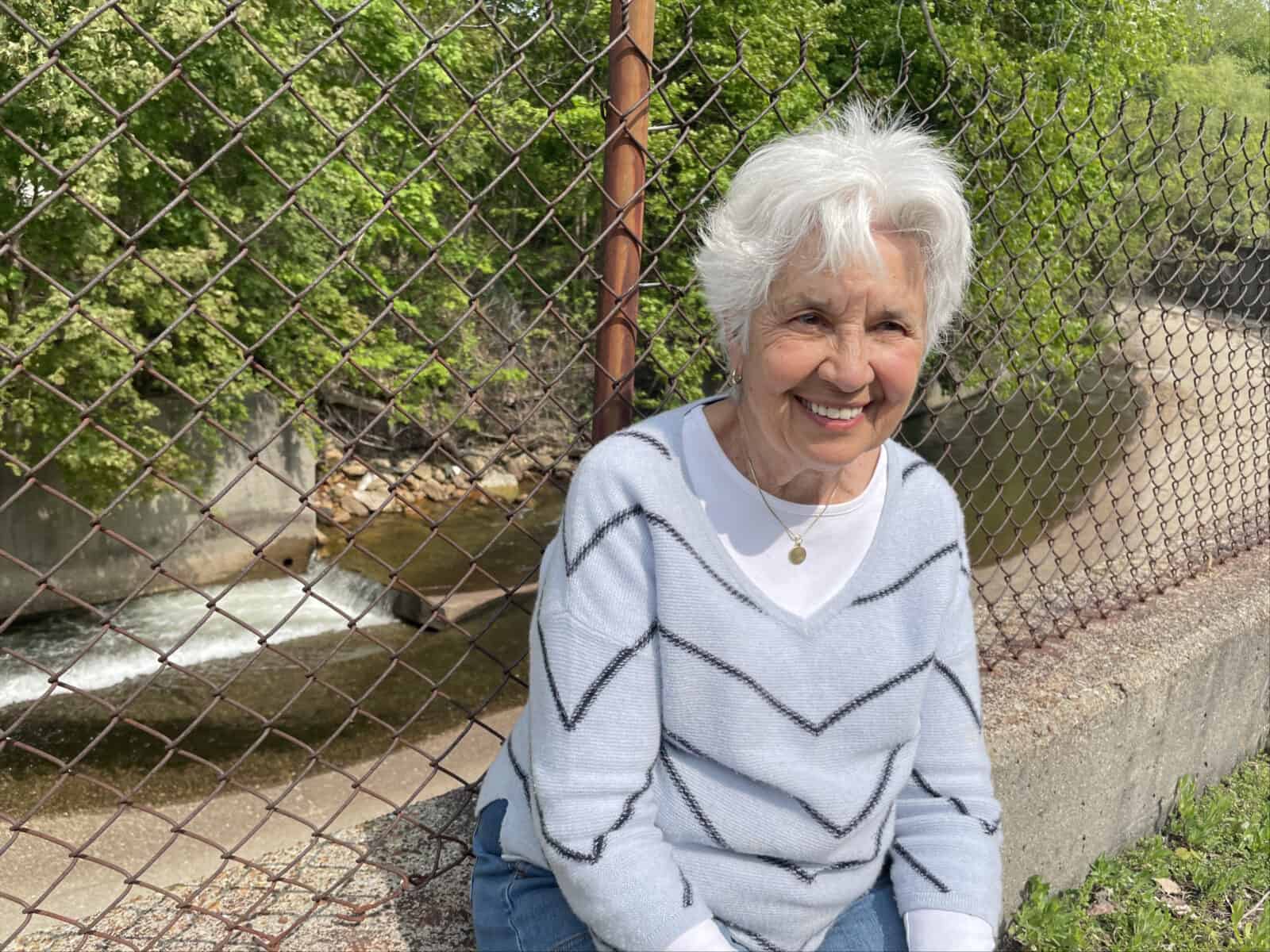 Judy Grinnell, executive director of Hoosic River Revival, sits by one of the flood chutes she is working hard to rethink with the city of North Adams.