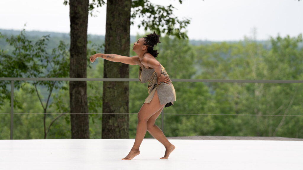 Bree Breeden rolls their shoulders, reaching out, as Kyle Marshall Choreography rehearses on the Leir outdoor stage. Photo courtesy of Jacob's Pillow Dance Festival