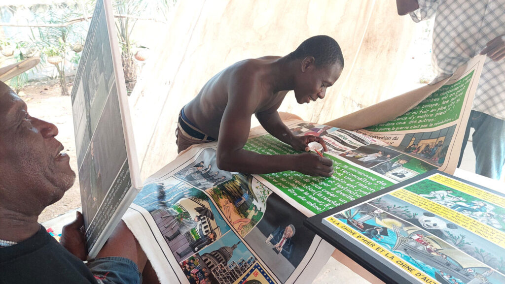 Internationally acclaimed artist Georges Adeagbo, left, works with an artist in his studio. Press photo courtesy of Chesterwood