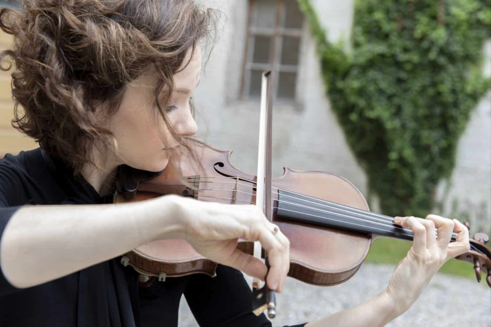 Acclaimed violinist Hilary Hahn bows her instrument in the sun. Press photo courtesy of the artist.