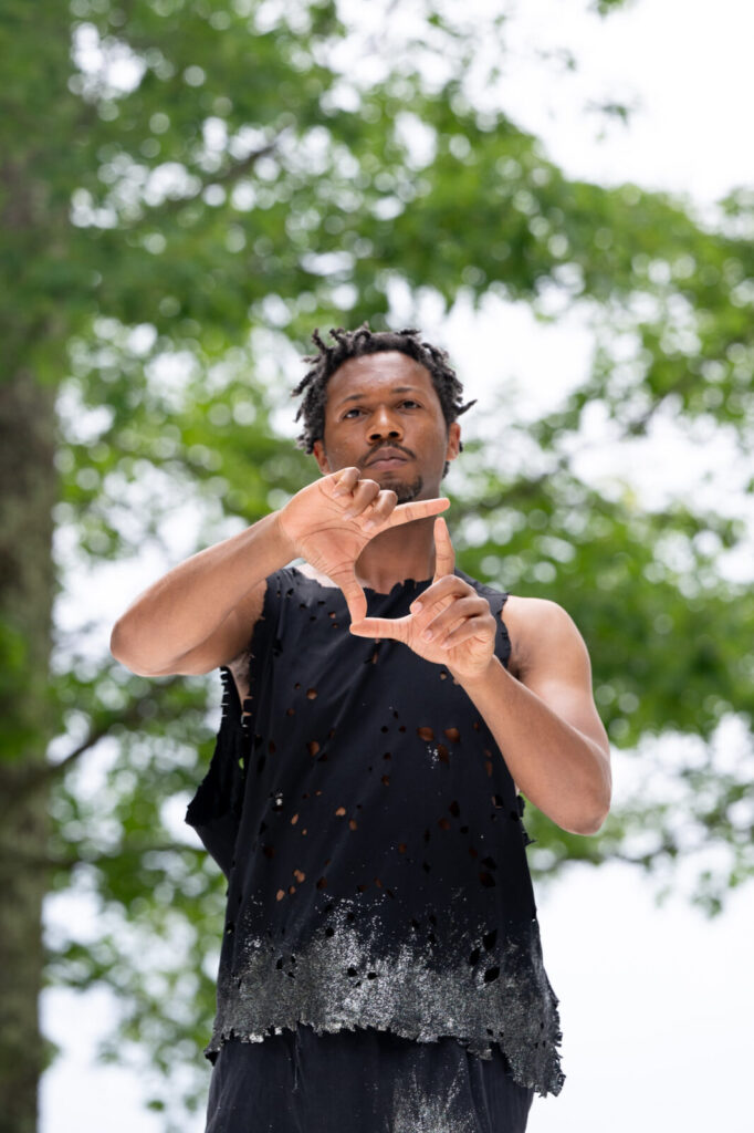 Kyle Marshall forms a diamond with his hands as he and his company rehearse on the Leir outdoor stage. Photo courtesy of Jacob's Pillow Dance Festival
