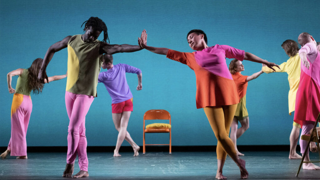 Mica Bernas and Brandon Randolph touch hands in a vibrantly colorful company of Mark Morris dancers performing The Look of Love. Photo courtesy of Jacob's Pillow Dance Festival