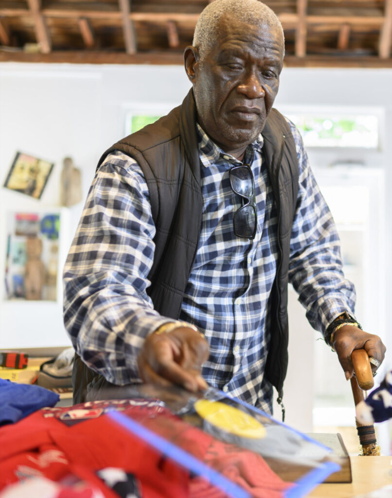 Internationally acclaimed artist Georges Adéagbo looks through records and books as he creates a site-specific art installation. Press photo courtesy of Chesterwood.