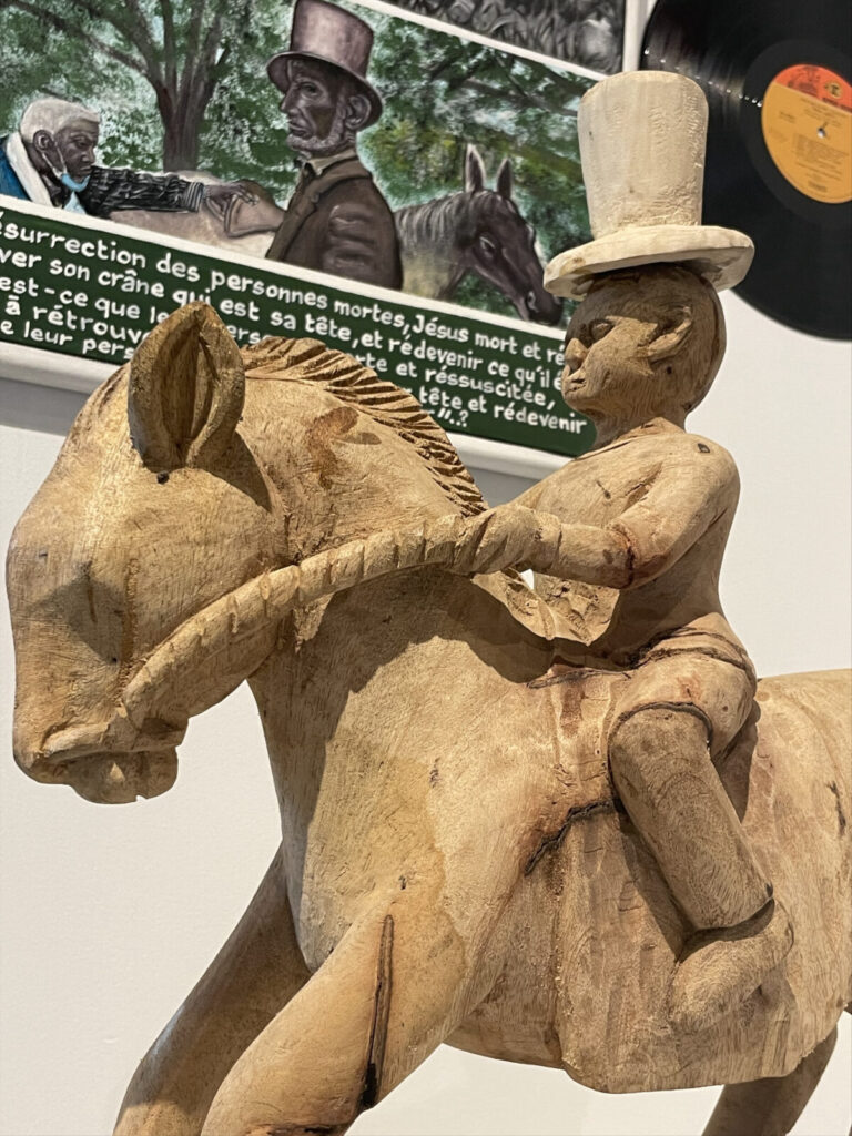 Abraham Lincoln rides on horseback alone through Washington D.C. in a woodword sculpture in George Adéagbo's site-specific art installation at Chesterwood.