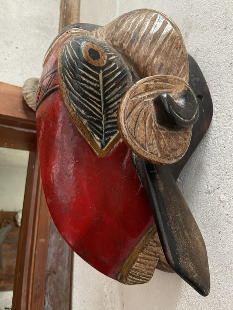 A red-beaked mask hangs over the door between Daniel Chester French's studio and the room where he mixed his plaster for casts in George Adéagbo's site-specific art installation at Chesterwood.