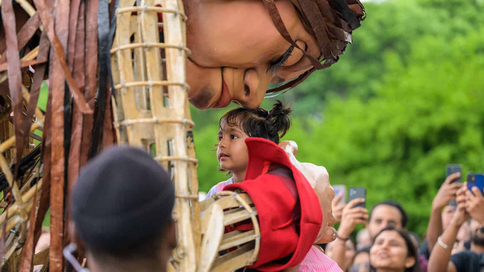 Amal - the 12-foot puppet and 10-year-old Syrian girl - welcomes a child in Toronto at the Luminato Festival - Press photo courtesy of The Walk Productions.