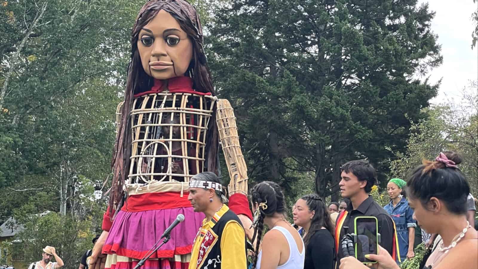 Amal - the 12-foot puppet, 10-year-old Syrian girl and global arts and human rights collaboration - meets Larry Spotted Crow Mann and his family on Ashfield common.