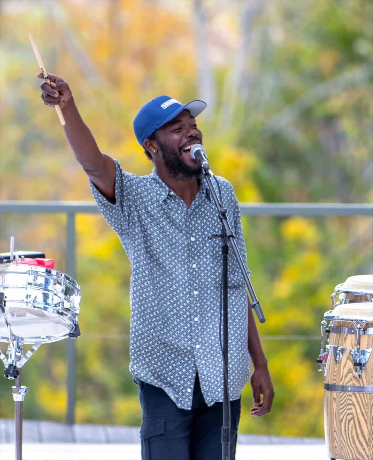 Internationally acclaimed percussionist Star Nii lifts a drumstick high and laughs as he performs at the BRIDGE gala. Press photo courtesy of BRIDGE