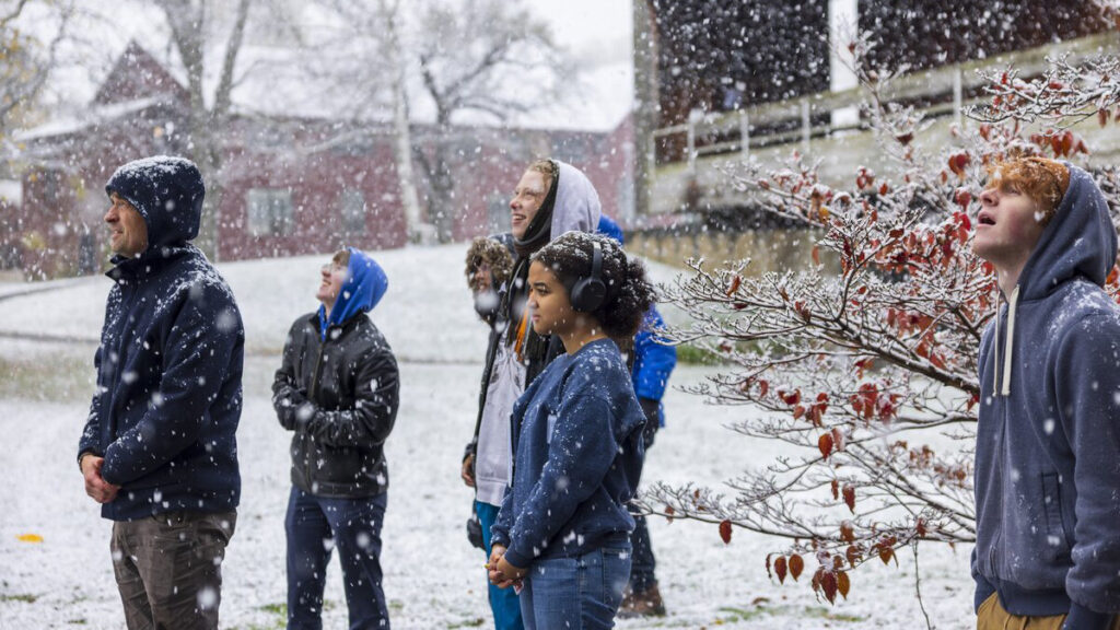Students in a physics class at Bennington college stand in the quad looking at the snow. Press photo courtesy of Bennington College