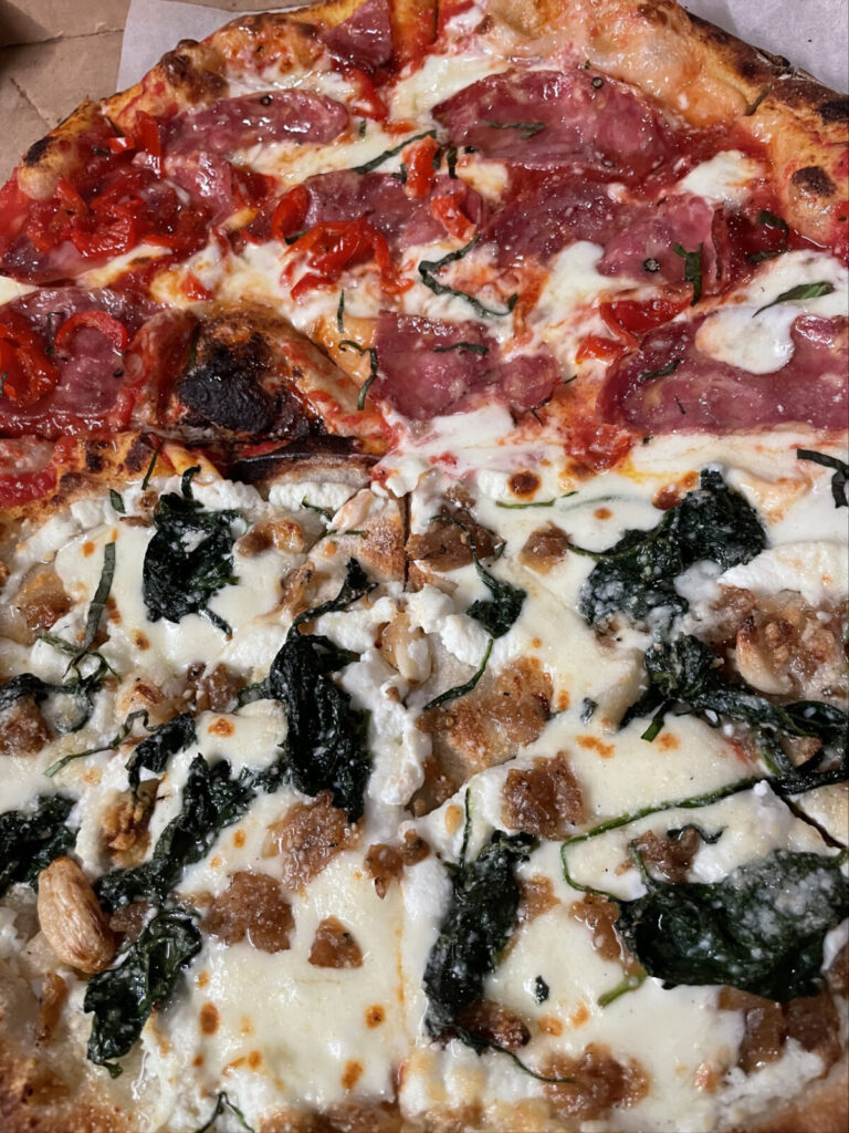 Roberto's pizza in Sheffield shows bright color on a crisp crust - half tomato and cheese, prosciutto amd pepper, and half a white pizza with ricotta and spinach.